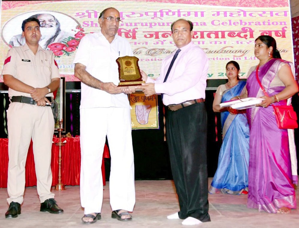 award receiving memento of maharishi birth centenary celebration